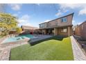Inviting backyard featuring a pool, spa, manicured turf, and a covered patio at 7584 Sweet Mist Ave, Las Vegas, NV 89178