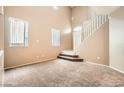 Bright living room with stairs, neutral carpet, and large windows at 8065 Starling View Ct, Las Vegas, NV 89166