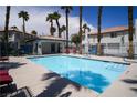Sparkling community pool surrounded by palm trees and lounge chairs for relaxation and recreation under the sunny sky at 8160 Autumn Star Ave, Las Vegas, NV 89145