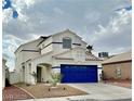 Charming two-story home with a striking blue garage door, complemented by a well-kept yard and desert landscaping at 8233 Hydra Ln, Las Vegas, NV 89128