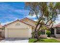 Inviting exterior view with a terracotta-tiled roof, well-manicured lawn, and an attached two-car garage at 8582 Manalang Rd, Las Vegas, NV 89123