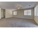 Spacious carpeted bedroom with ceiling fan and multiple windows for natural light at 8980 High Horizon Ave, Las Vegas, NV 89149