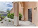 Close-up of the front door with decorative metal security screen, pillars, and desert landscaping at 8980 High Horizon Ave, Las Vegas, NV 89149