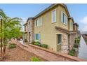 Charming townhome showcasing stone accents, a tiled roof, and verdant landscaping at 965 Nevada State Dr # 8202, Henderson, NV 89002