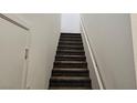 Carpeted staircase with neutral walls and white trim, leading to the upper level at 965 Nevada State Dr # 8202, Henderson, NV 89002