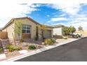 A street view of the single story home, showcasing desert landscaping and brick driveway at 9993 Skye Gazer Ave, Las Vegas, NV 89166