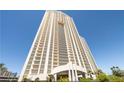 Expansive high-rise condo exterior with grand entrance and lush landscaping against a bright blue sky at 145 E Harmon Ave # 2021, Las Vegas, NV 89109