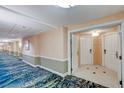 Hotel hallway with patterned blue carpet and light peach walls and entrance doors at 145 E Harmon Ave # 2021, Las Vegas, NV 89109