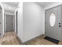 Bright entryway featuring a decorative glass front door, wood flooring, and freshly painted white walls at 2500 Holly Ave, Las Vegas, NV 89106