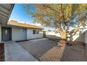 Inviting front yard with desert landscaping and a mature shade tree, leading to a cozy single-story home at 2500 Holly Ave, Las Vegas, NV 89106