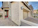Home's exterior has stone accents, a private drive, and a red front door at 31 Castleton Tower Ct, Henderson, NV 89011