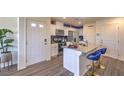Bright kitchen featuring white cabinets, stainless appliances, an island with bar seating, and stylish blue accents at 4806 Lilac Ridge Ave # 31, Las Vegas, NV 89141
