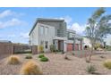 Stylish home with modern design, gray exterior, three-car garage, and desert landscaping at 8591 Cloudy Dawn Way, Las Vegas, NV 89113