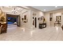 Elegant foyer with tiled floors, chandelier, and view of outdoor patio through glass doors at 9117 Hickam Ave, Las Vegas, NV 89129