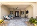 Inviting covered patio with seating, ceiling fan, and outdoor television for relaxation and entertainment at 9117 Hickam Ave, Las Vegas, NV 89129