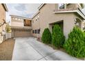 Side view of home showcasing a two-car garage and an elevated outdoor balcony space at 10450 Kepler Cascades St, Las Vegas, NV 89141