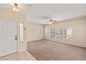 Bright living room with neutral carpet, ceiling fan, and large windows at 10730 Amber Ridge Dr # 205, Las Vegas, NV 89144