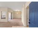 Open-concept living room with neutral carpet, sliding door to balcony, and modern lighting at 10730 Amber Ridge Dr # 205, Las Vegas, NV 89144