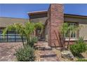 Home exterior highlighting brick accents, desert landscaping, and a paved pathway leading to the entrance at 11185 Black Fire Opal Dr, Las Vegas, NV 89138