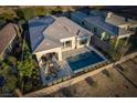 Aerial view of an elegant home featuring a backyard pool, covered patio with dining area, and well-kept landscaping at 13 Porto Malaga St, Henderson, NV 89011