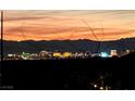 Expansive city skyline view with colorful buildings and mountain silhouette against a vibrant orange and pink sunset at 13 Porto Malaga St, Henderson, NV 89011