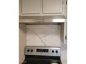 Close-up of the kitchen area featuring an updated range hood and marbled backsplash at 205 E Harmon Ave # 212, Las Vegas, NV 89169