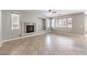Open living room featuring a fireplace, tile flooring, and large windows allowing lots of natural light at 3725 Moonshine Falls Ave, North Las Vegas, NV 89085