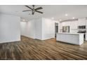 Open-concept living and kitchen area featuring wood-look floors, neutral paint, and modern ceiling fan at 3909 Grazing Gazelle Ave, North Las Vegas, NV 89084
