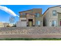 Eye-level view of a contemporary two-story home with rock landscaping and stone facade accents at 534 Lassen Falls Ct, Henderson, NV 89044
