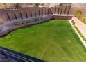 Expansive backyard featuring a lush lawn, retaining wall, mature trees, and landscape for outdoor enjoyment at 6197 Jewel Vista St, Las Vegas, NV 89135