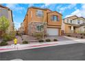 Two-story home with stone accents, well-manicured landscaping, and a two-car garage with brick driveway at 632 Loyalty Ct, Henderson, NV 89011