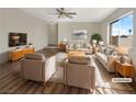 Bright living room with hardwood floors, neutral paint, large windows, and comfortable seating arrangement. (Virtually Staged) at 6479 Gunderson Blvd, Las Vegas, NV 89103