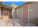 Inviting covered entry featuring two exterior doors, manicured gravel, and a 