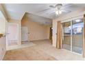 Open living area with carpet and tile flooring, plus a sliding glass door to the outside at 6955 N Durango Dr # 3019, Las Vegas, NV 89149