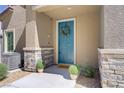 Charming front entrance showcasing a blue door with wreath and decorative potted plants with stone veneer accents at 7350 N Decatur Blvd # 5, Las Vegas, NV 89131