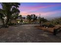 Wide front exterior view of this single-story home featuring desert landscaping, a brick driveway and mature trees at 800 Kenny Way, Las Vegas, NV 89107