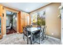 Bright dining area with a large window and tile flooring adjacent to the kitchen and hallway at 8224 Chimney Bluffs St, North Las Vegas, NV 89085