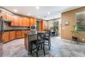 Spacious eat-in kitchen featuring an island with breakfast bar, stone floors and ample cabinetry at 8224 Chimney Bluffs St, North Las Vegas, NV 89085