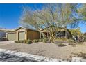 Tan single-story home featuring a well-manicured front yard and desert landscaping at 8514 Garnet Lake Ave, Las Vegas, NV 89113