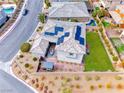 Stunning aerial view of the home's backyard featuring a lush green lawn and solar panels at 940 Riverlawn Pl, Las Vegas, NV 89138