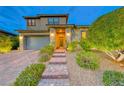 Charming two-story home with a two-car garage and brick steps leading to the entrance at 940 Riverlawn Pl, Las Vegas, NV 89138