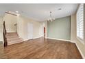Bright living room featuring wood floors, a chandelier, and a staircase to the upper level at 10247 Gladstone Peak St, Las Vegas, NV 89166