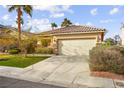 Inviting one-story home featuring a spacious driveway, desert landscaping, and an attached two-car garage at 1184 Warm Canyon Way, Las Vegas, NV 89123