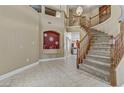 Elegant foyer with a winding staircase and tile flooring, creating a grand entrance at 1730 Juniper Twig Ave, Las Vegas, NV 89183