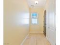 Hallway with tile flooring, arched doorway, window with blinds, and neutral paint at 26 Via Vasari # 204, Henderson, NV 89011