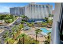 Beautiful view of the community pool surrounded by palm trees and city views at 322 Karen Ave # 703, Las Vegas, NV 89109