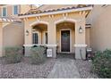 Welcoming front porch with seating, desert landscaping, and a dark wood front door at 3281 Pergusa Dr, Henderson, NV 89044