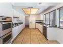 Bright kitchen with stainless steel appliances, white cabinetry and tile floor at 4406 Flowerdale Ct, Las Vegas, NV 89103