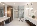 Modern bathroom with dual vanities, a glass-enclosed shower, and sleek, contemporary fixtures at 501 Proud Eagle Ln, Las Vegas, NV 89144