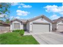 Single-story home with a two-car garage, neutral paint, and green front lawn at 5988 Turtle River Ave, Las Vegas, NV 89156
